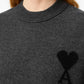 Gray sweater with a black heart and letter 'A' design on a beige background