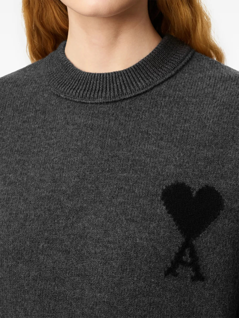 Gray sweater with a black heart and letter 'A' design on a beige background