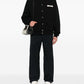 Black varsity jacket with a logo on the chest against a white background