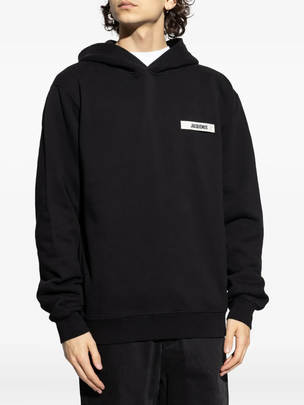 Black hoodie with a small logo on the chest against a white background