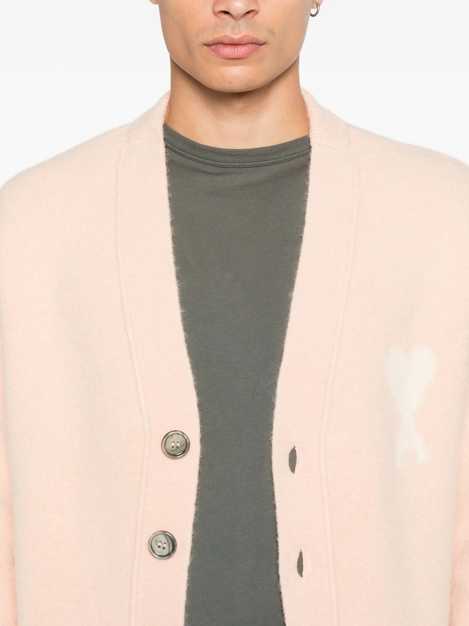 Pink cardigan with button details and a bow design on a white background ami paris
