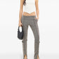 Woman wearing gray high-waisted pants with cut-out sides on a white background