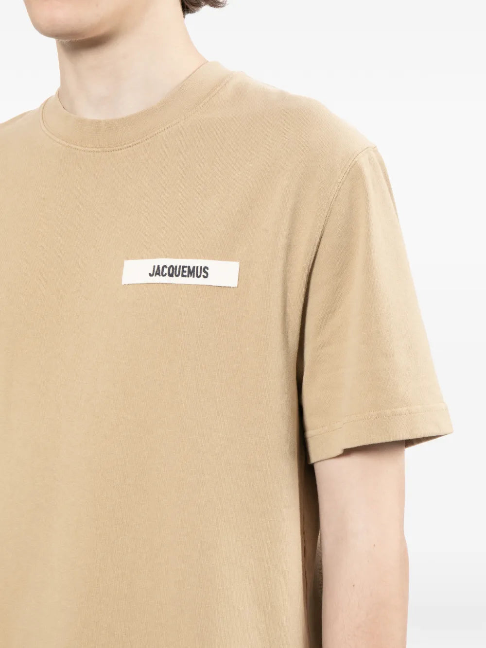 dark beige t-shirt with a small logo on a white background