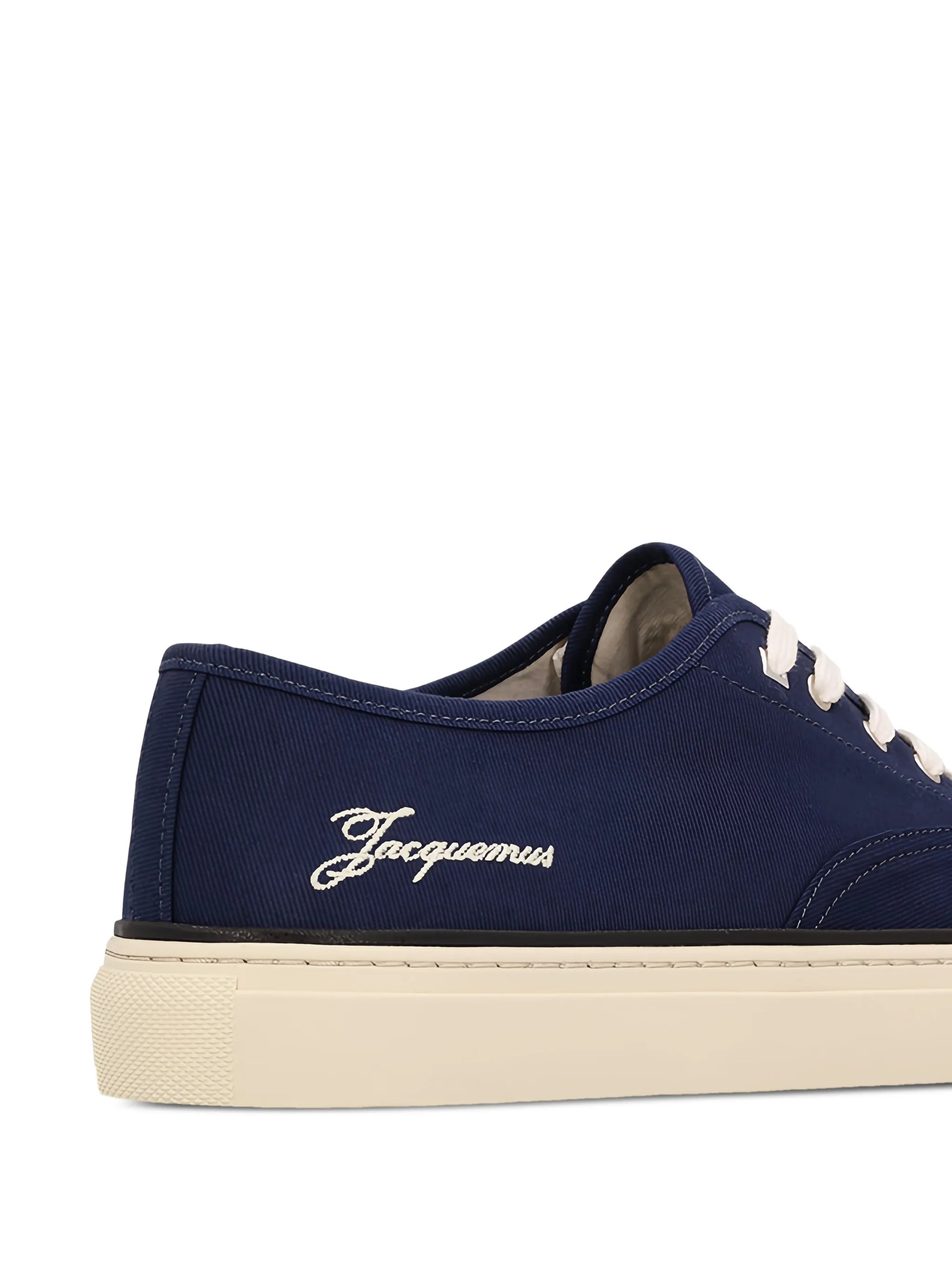 Navy blue sneaker with white laces on a white background