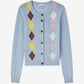 A light blue cardigan sweater with vertical argyle diamond patterns in brown, yellow, pink, and white on the front, featuring a button-up front and a visible GANNI brand label.