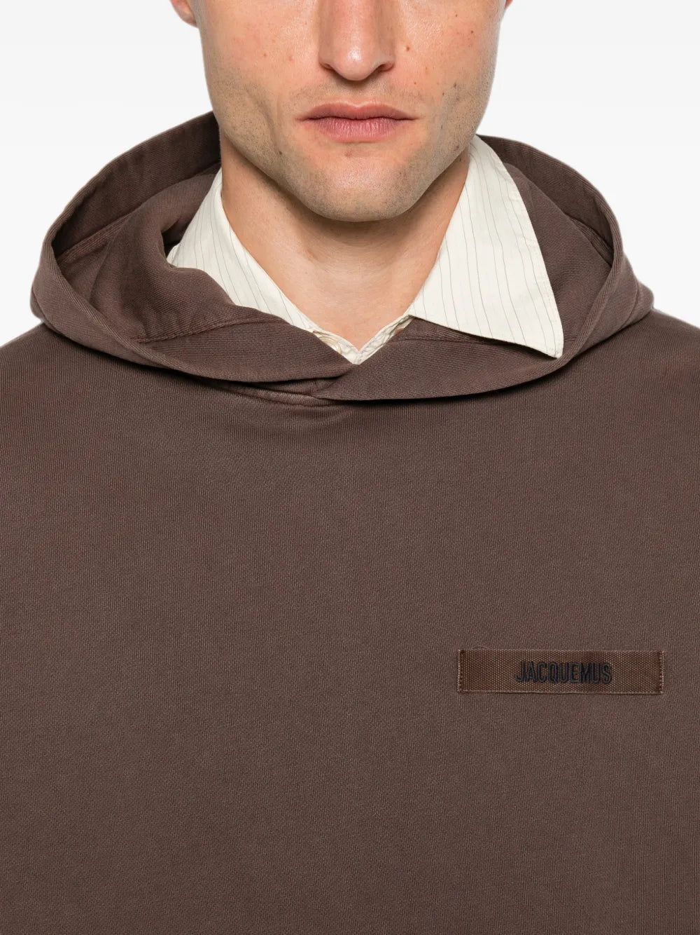 brown hoodie with a small logo on the chest against a white background