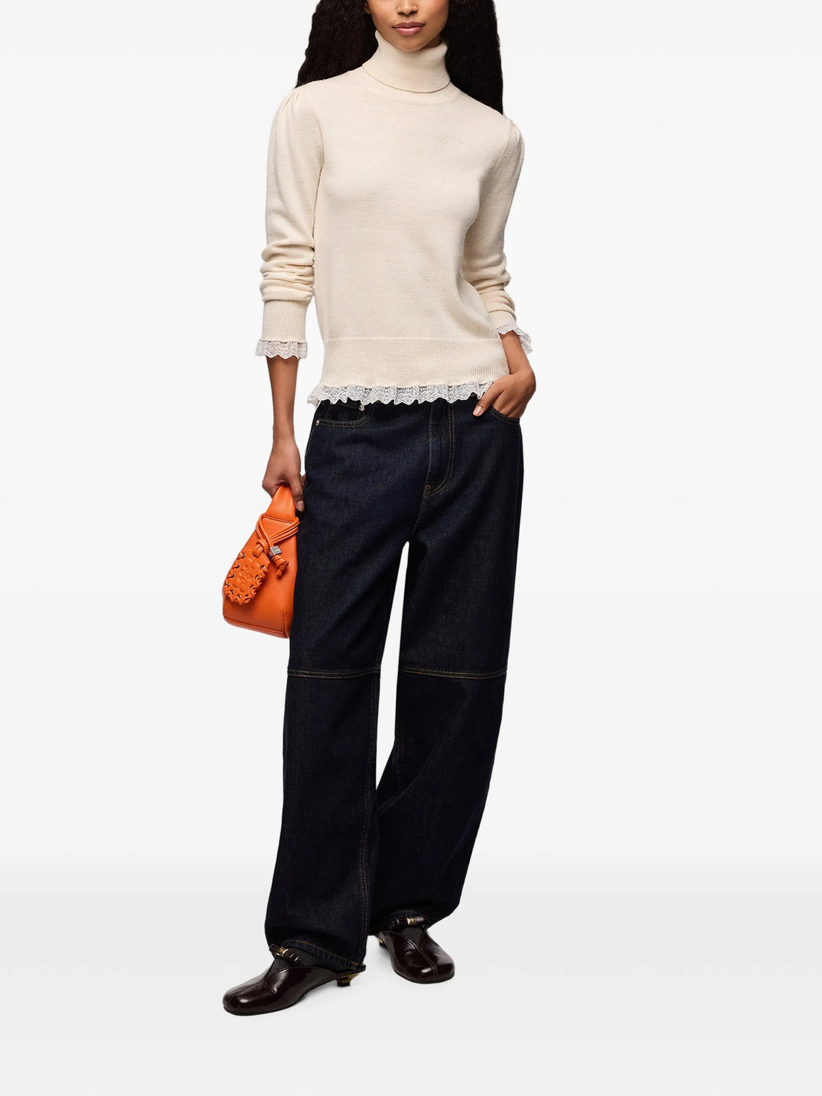 A light beige knit turtleneck sweater with long sleeves and a sheer ruffled hem, displayed against a plain white background.
