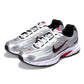 Pair of silver Nike running shoes with black and red accents on a white background