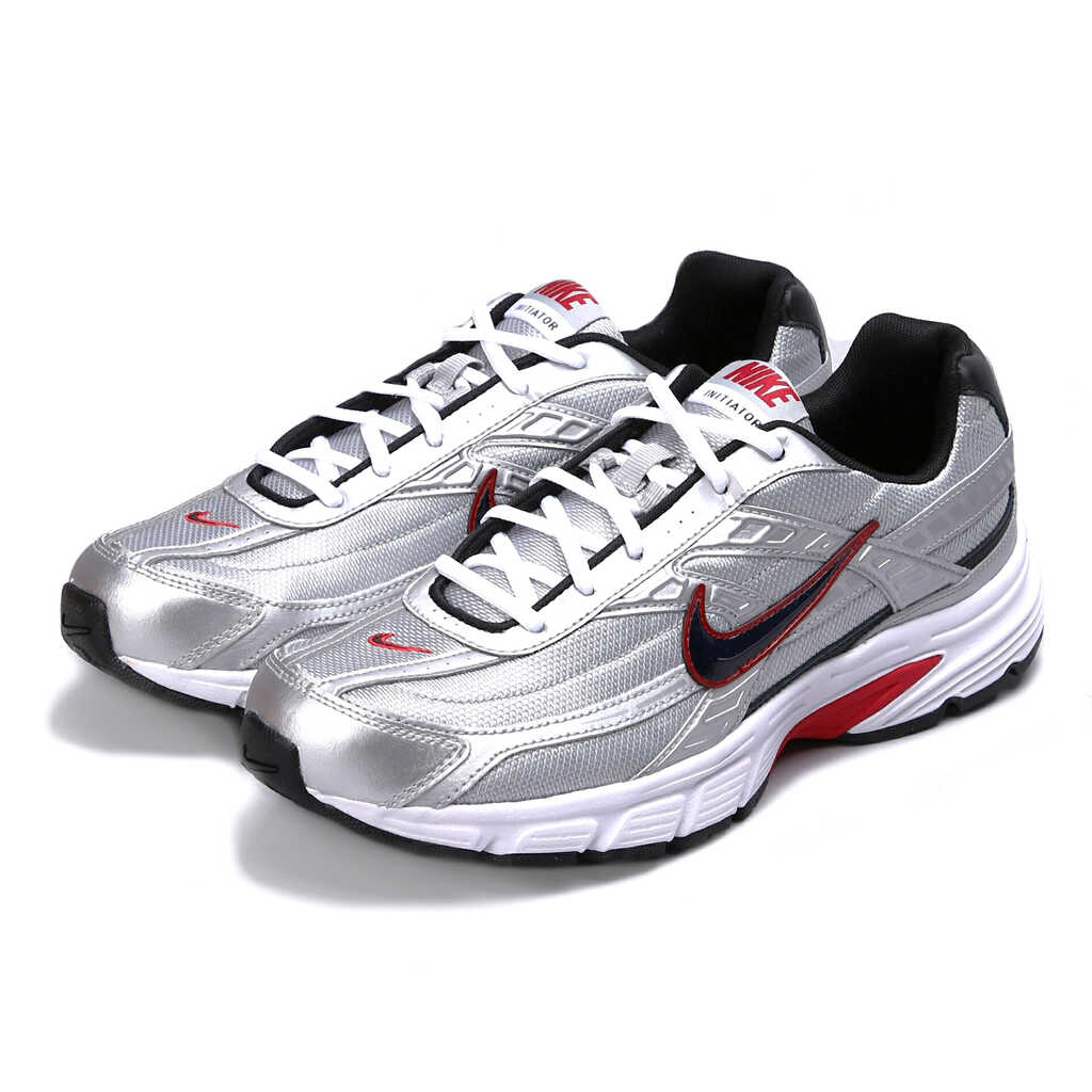 Pair of silver Nike running shoes with black and red accents on a white background