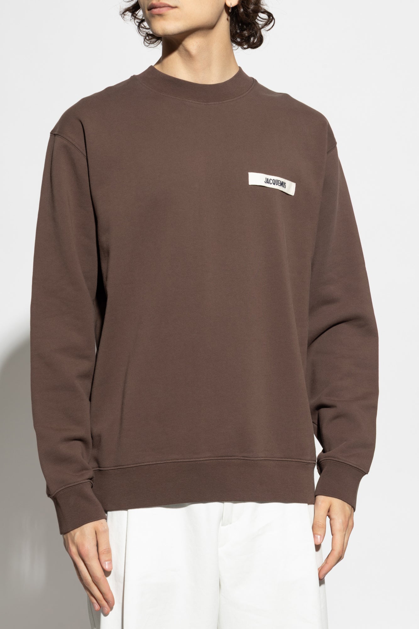 Brown sweatshirt with a small logo on a white background