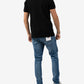 Person wearing a black polo shirt and blue jeans on a white background