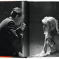 Open book showing a black and white photograph of a man and woman in a close interaction.