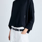 Person wearing a black sweater with a logo on a white background
