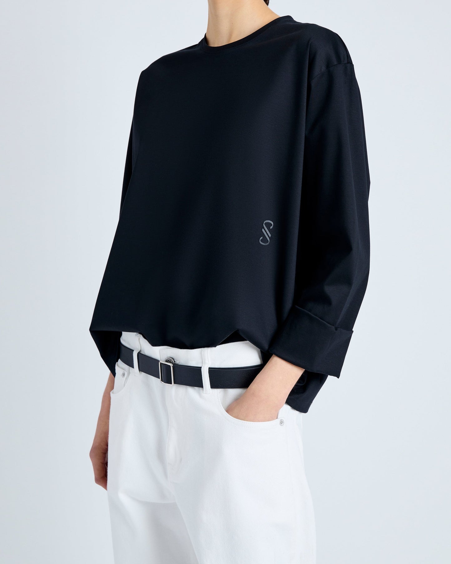 Person wearing a black sweater with a logo on a white background