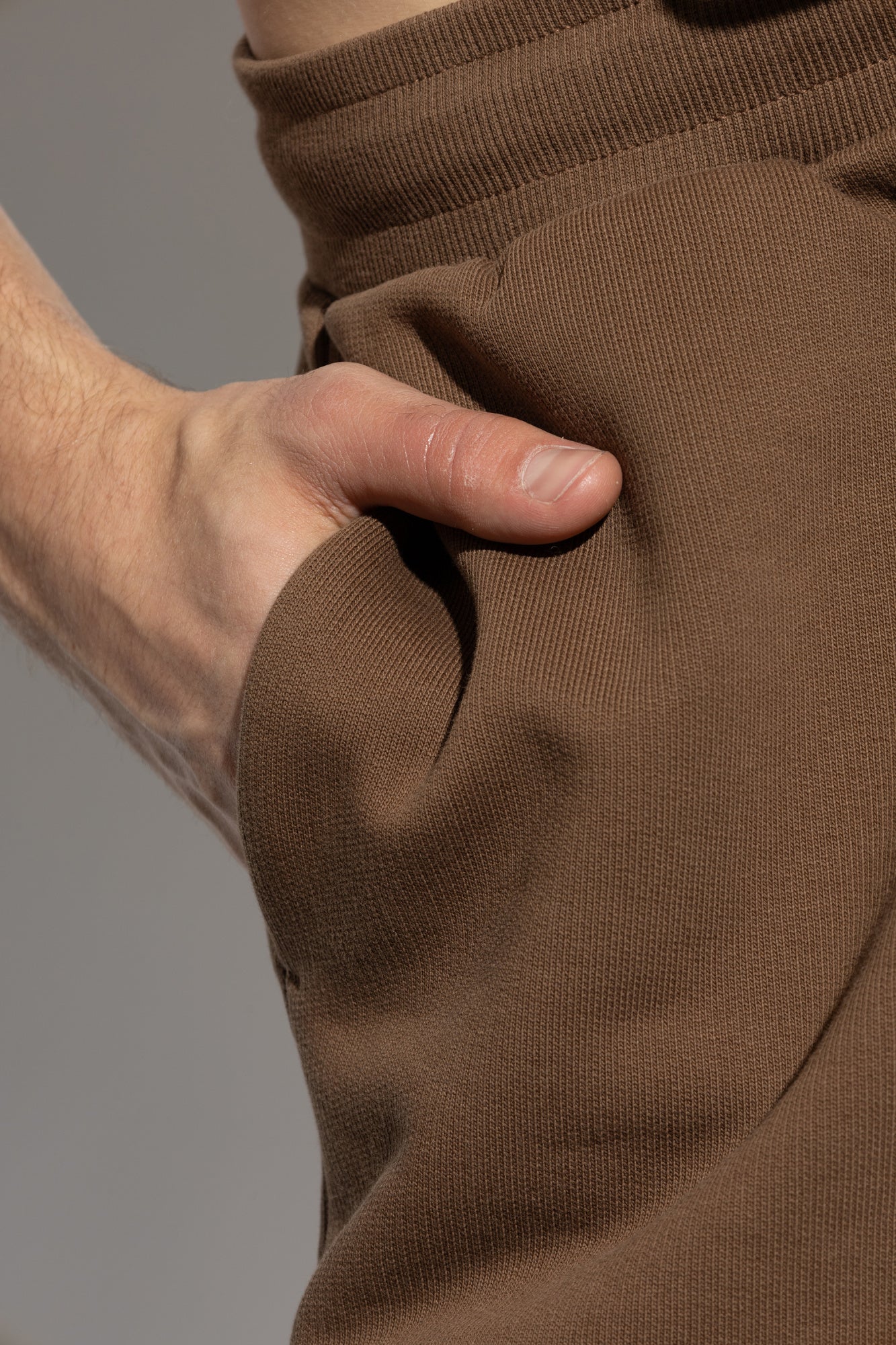 Brown sweatpants with a drawstring on a white background
