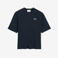 Navy blue t-shirt with 'ami' logo on a beige background ami paris
