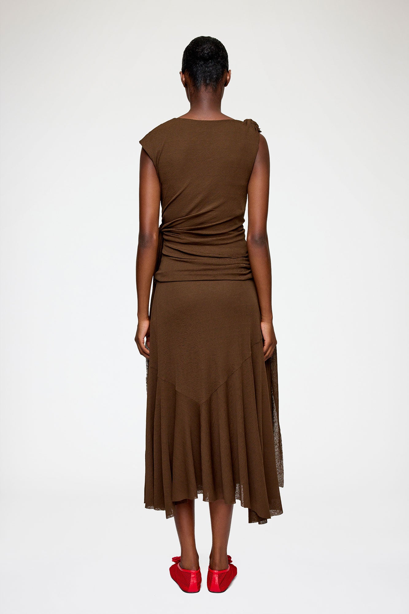 Brown sleeveless dress with a draped design on a white background