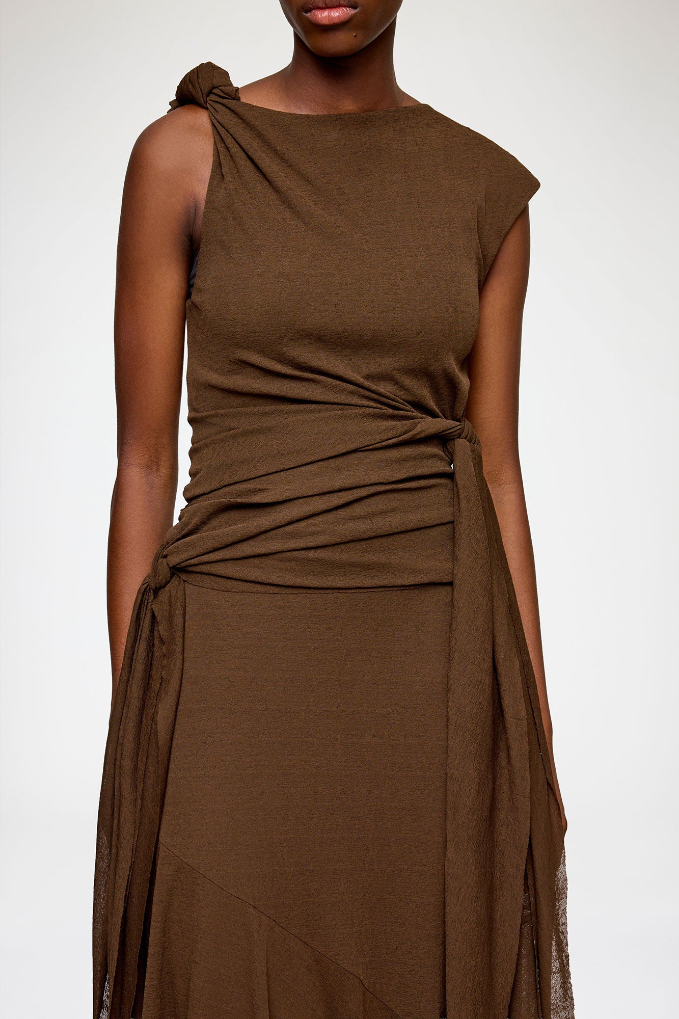 Brown sleeveless dress with a draped design on a white background
