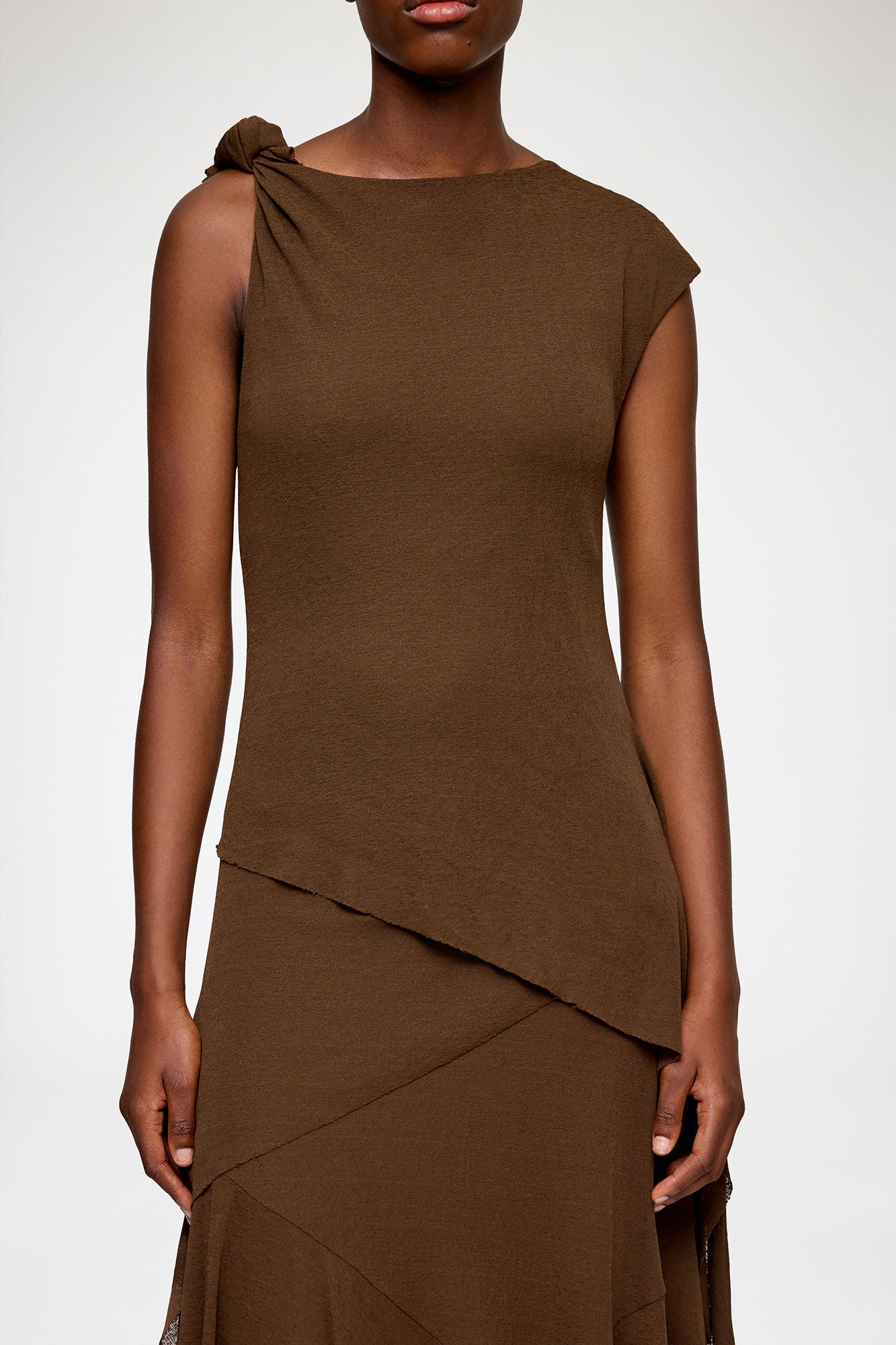 Brown sleeveless dress with a draped design on a white background