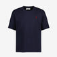 Navy blue t-shirt with a small red logo on a light gray background