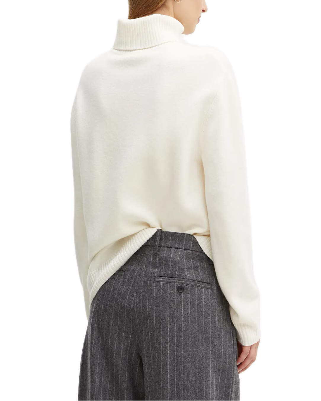 Person wearing a cream sweater and gray pinstripe pants on a white background