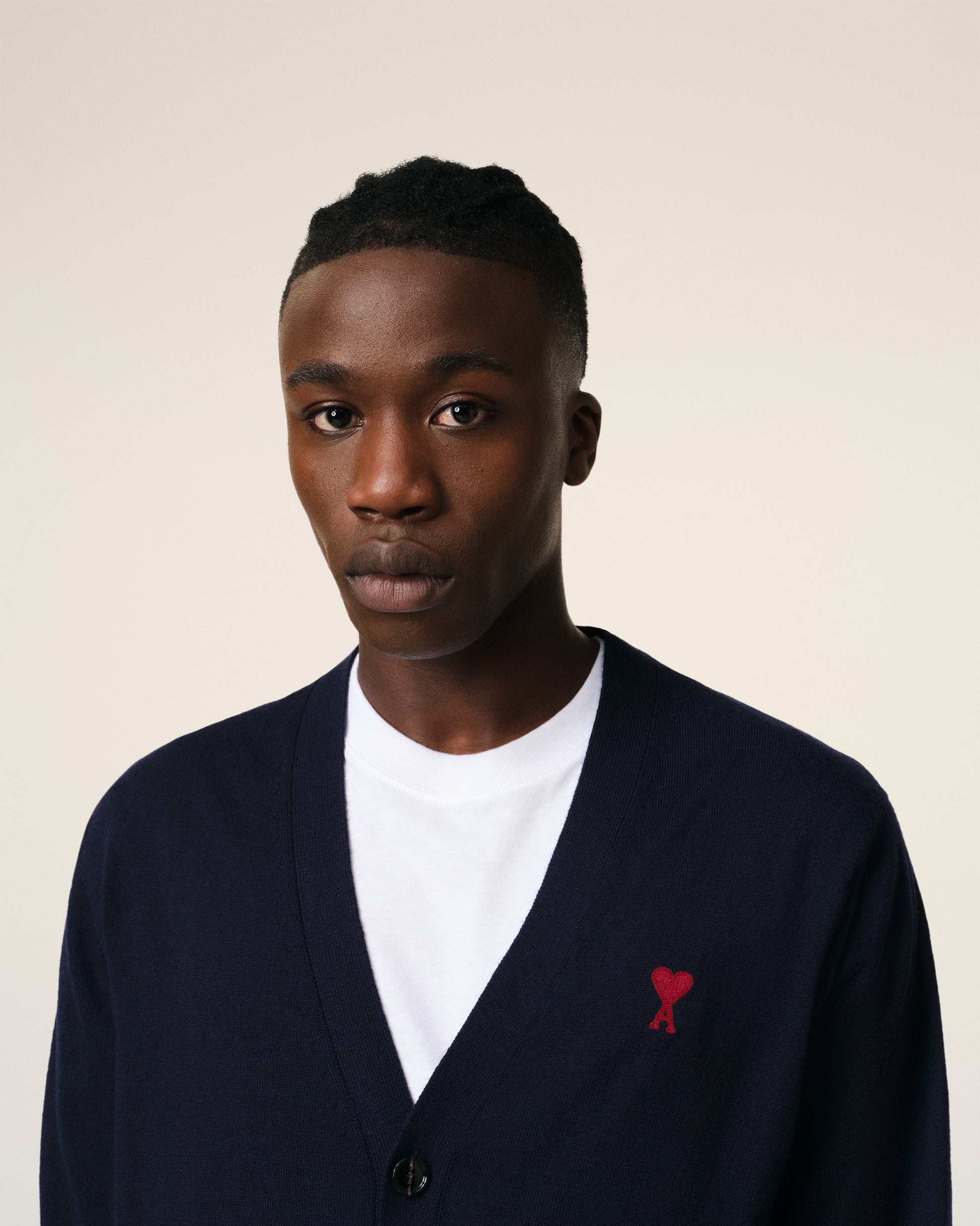 Navy blue cardigan with a red logo on a white background