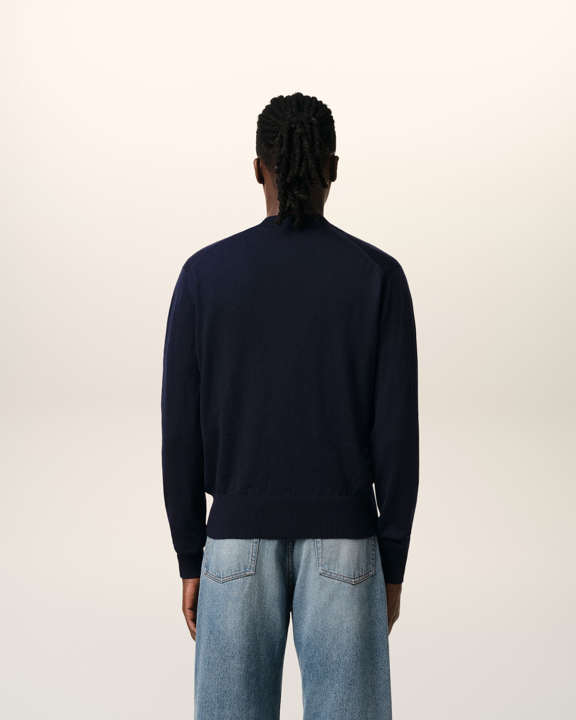 Navy blue cardigan with a red logo on a white background