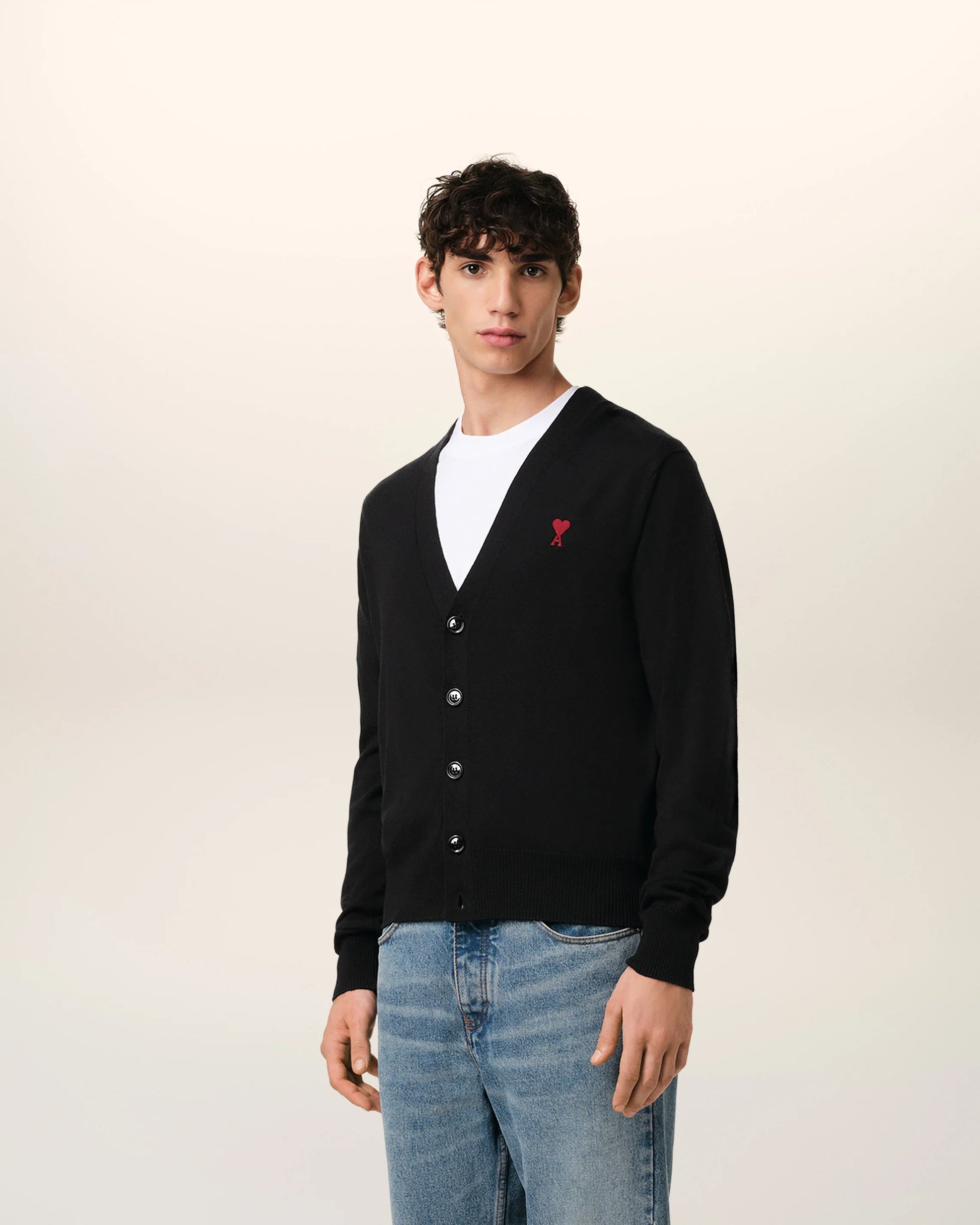 Black cardigan with a small red heart emblem on a white background