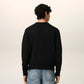 Black cardigan with a small red heart emblem on a white background