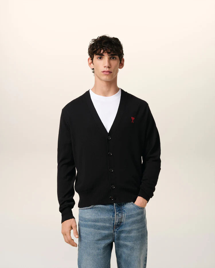Black cardigan with a small red heart emblem on a white background