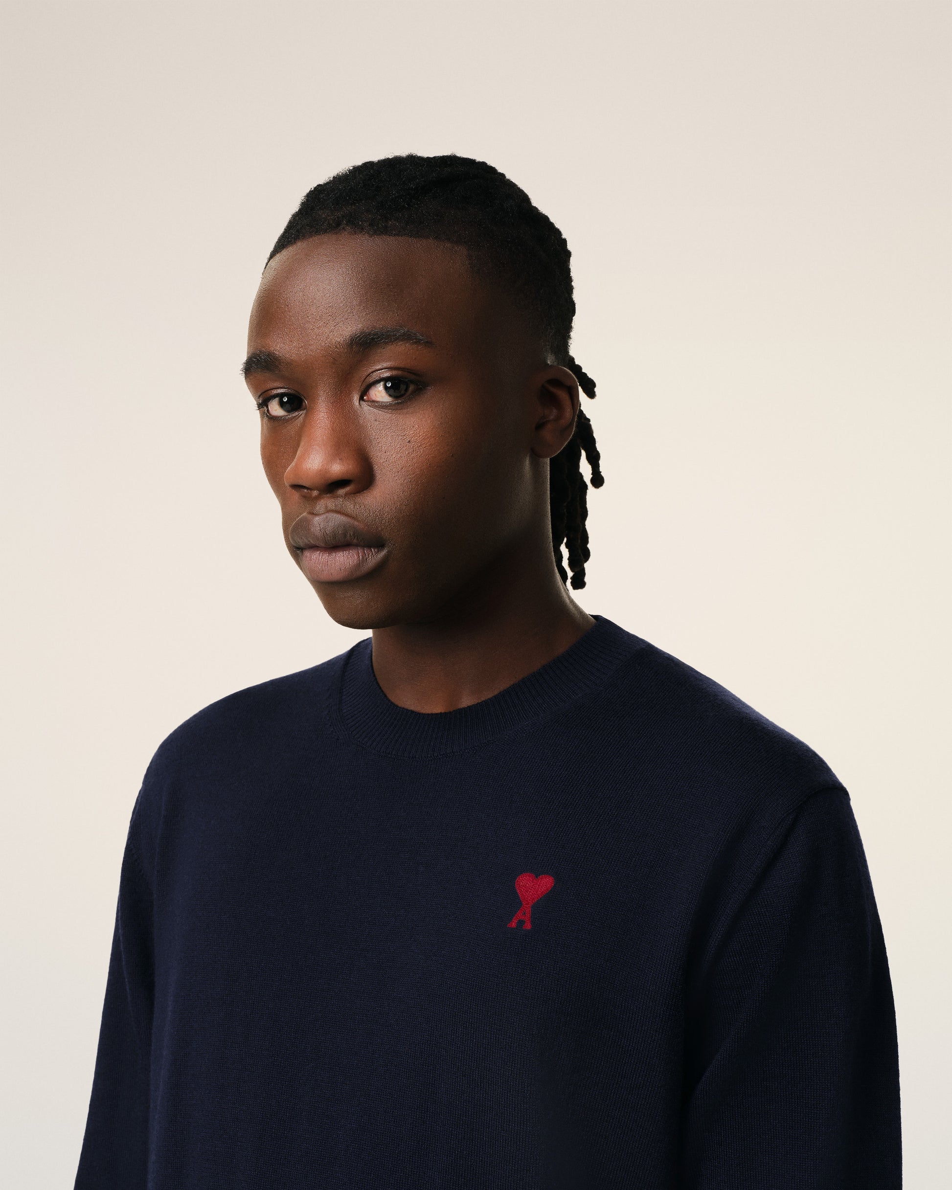 Navy blue sweater with a red heart and letter 'A' logo on a white background