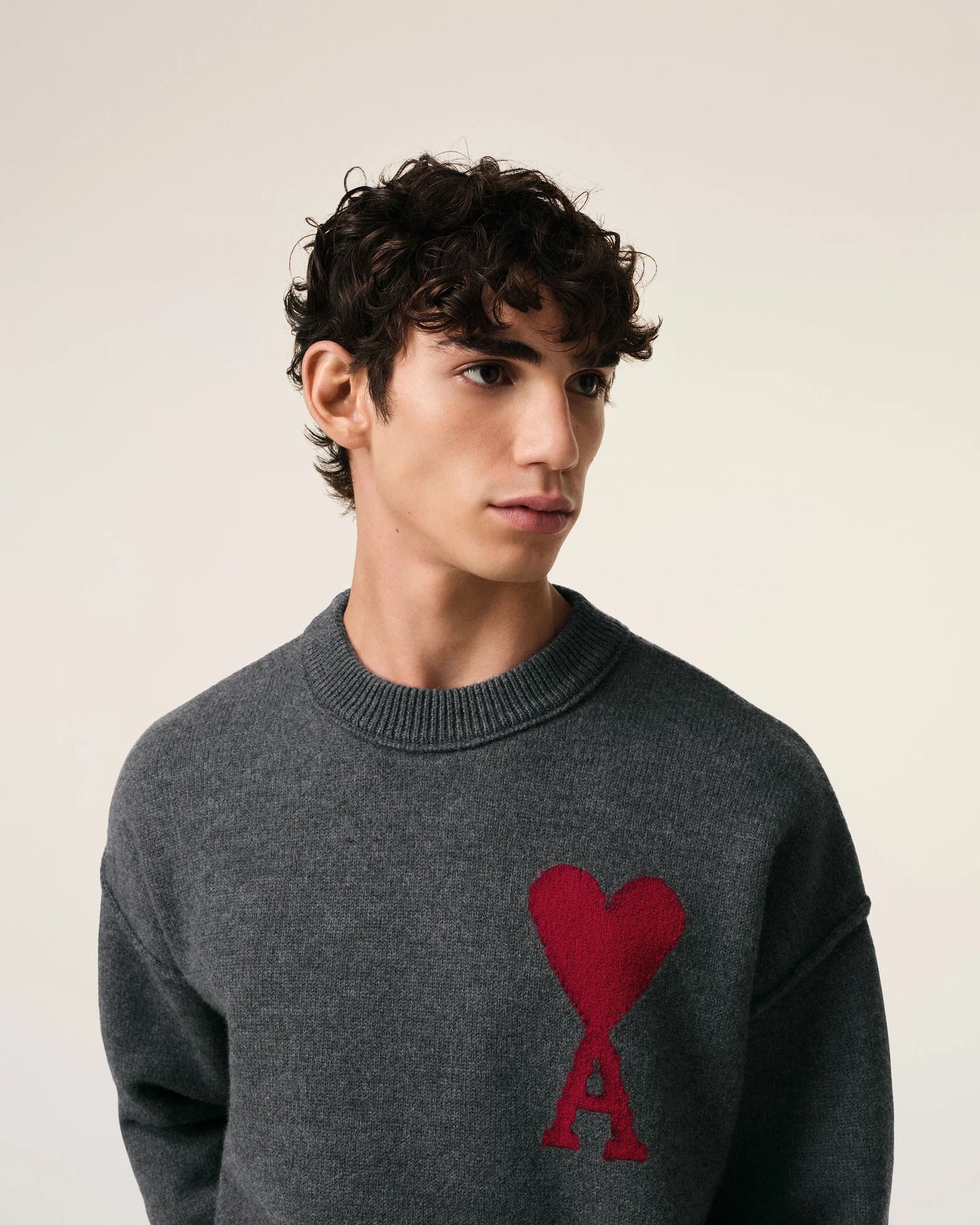 Gray sweater with a red heart design on a beige background