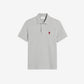 Gray polo shirt with a small red logo on a beige background