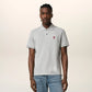 Gray polo shirt with a small red logo on a beige background