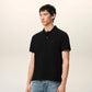 Black polo shirt with a red heart emblem on a beige background ami paris