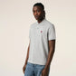 Gray polo shirt with a small red logo on a beige background