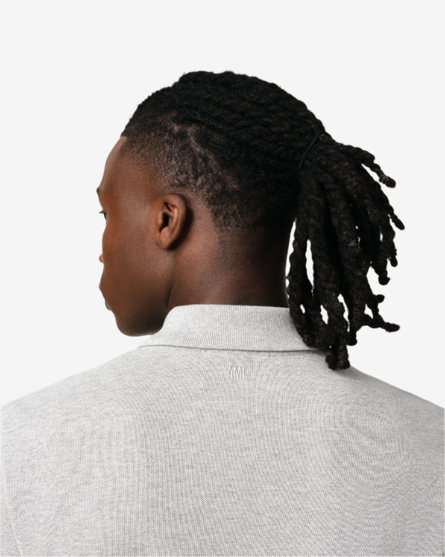 Gray polo shirt with a small red logo on a beige background
