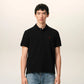 Black polo shirt with a red heart emblem on a beige background ami paris