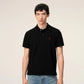 Black polo shirt with a red heart emblem on a beige background ami paris
