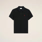 Black polo shirt with a red heart emblem on a beige background ami paris