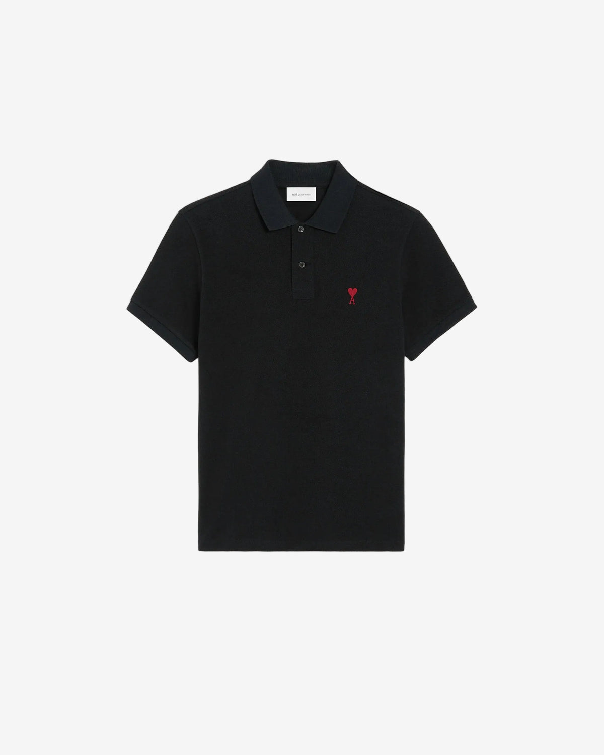 Black polo shirt with a red heart emblem on a beige background ami paris