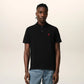 Black polo shirt with a small red logo on a beige background