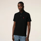 Black polo shirt with a small red logo on a beige background