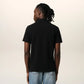 Black polo shirt with a small red logo on a beige background