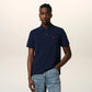 Navy blue polo shirt with a red heart logo on a beige background