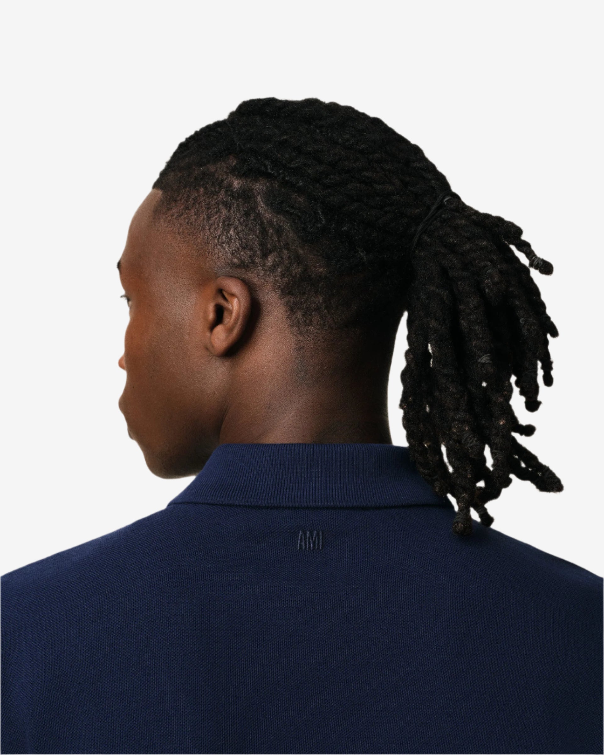 Navy blue polo shirt with a red heart logo on a beige background