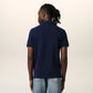 Navy blue polo shirt with a red heart logo on a beige background
