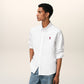 White polo shirt with a red logo on a beige background