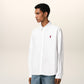 White polo shirt with a red logo on a beige background