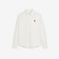 White polo shirt with a red logo on a beige background